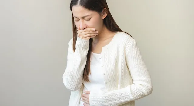 吐き気を我慢している女性